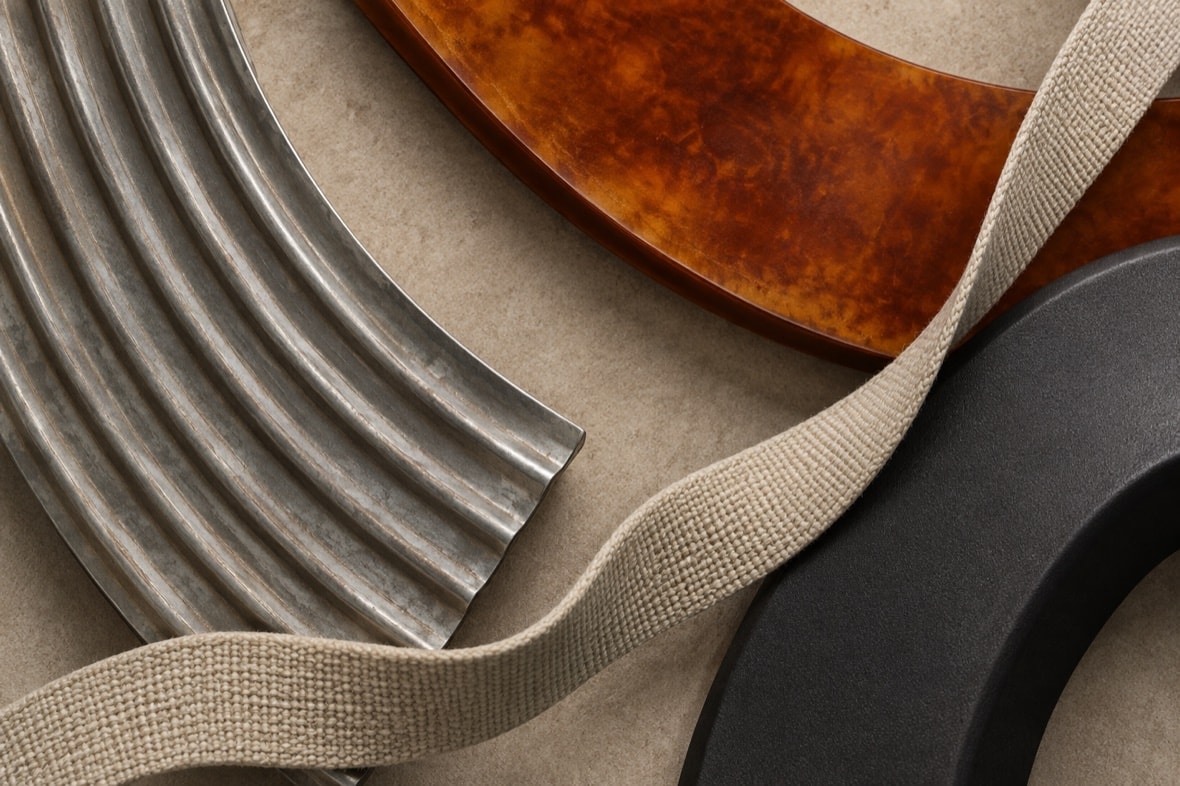 Pressed steel, amber composite, black polymer and woven webbing material samples